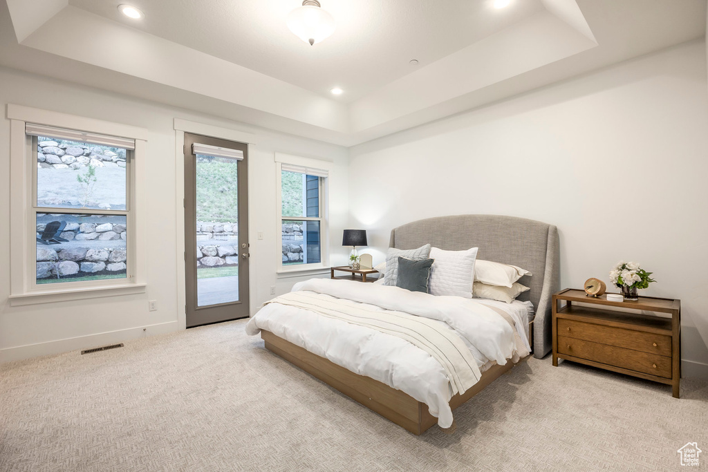 Carpeted bedroom featuring a raised ceiling, access to outside, baseboards, and recessed lighting