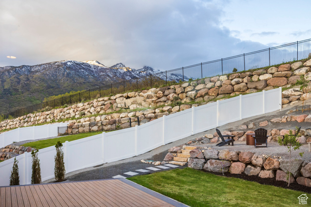 Fenced backyard with a fire pit and a mountain view
