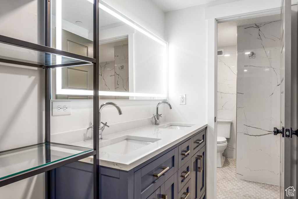 Full bath featuring toilet and double vanity