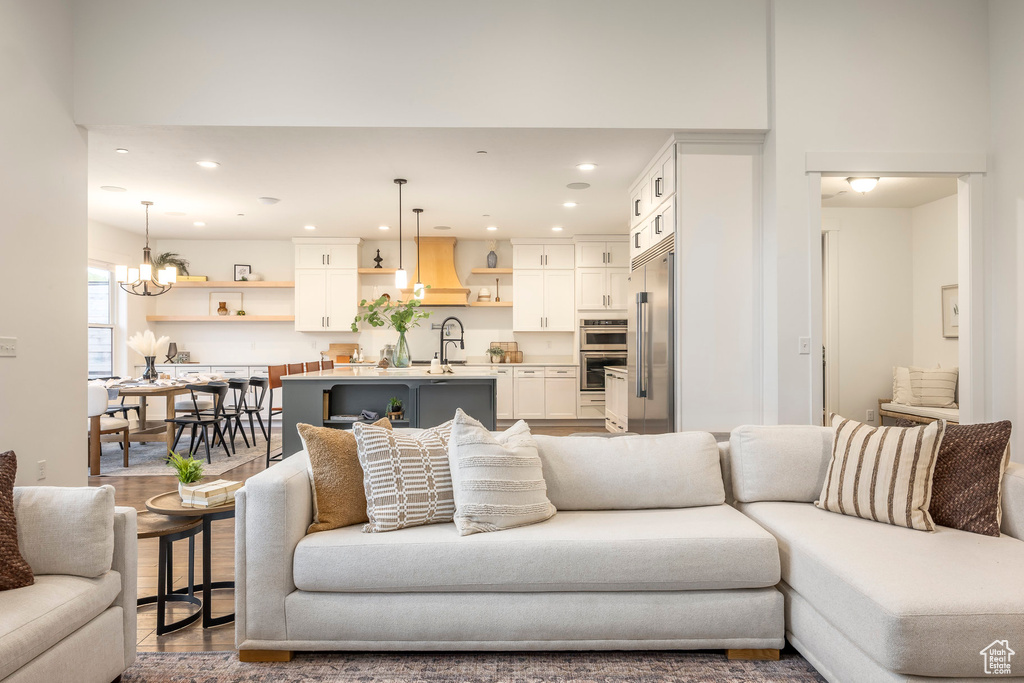 Living area with recessed lighting, a chandelier, and wood finished floors