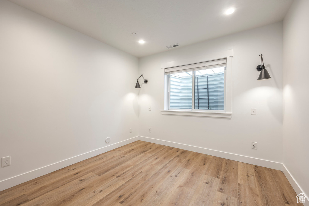Unfurnished room with baseboards, light wood finished floors, and recessed lighting