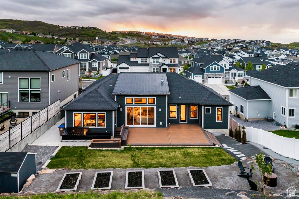 Back of property at dusk with a residential view and a deck