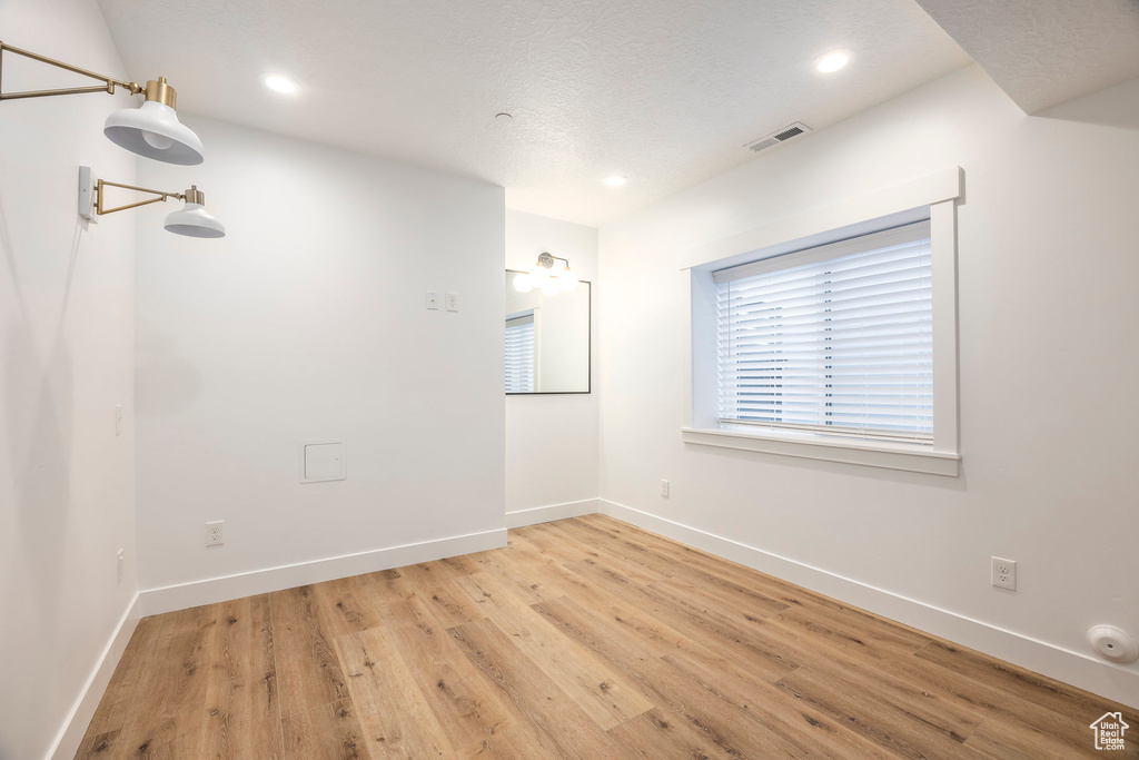 Spare room featuring light wood-style flooring, baseboards, and recessed lighting