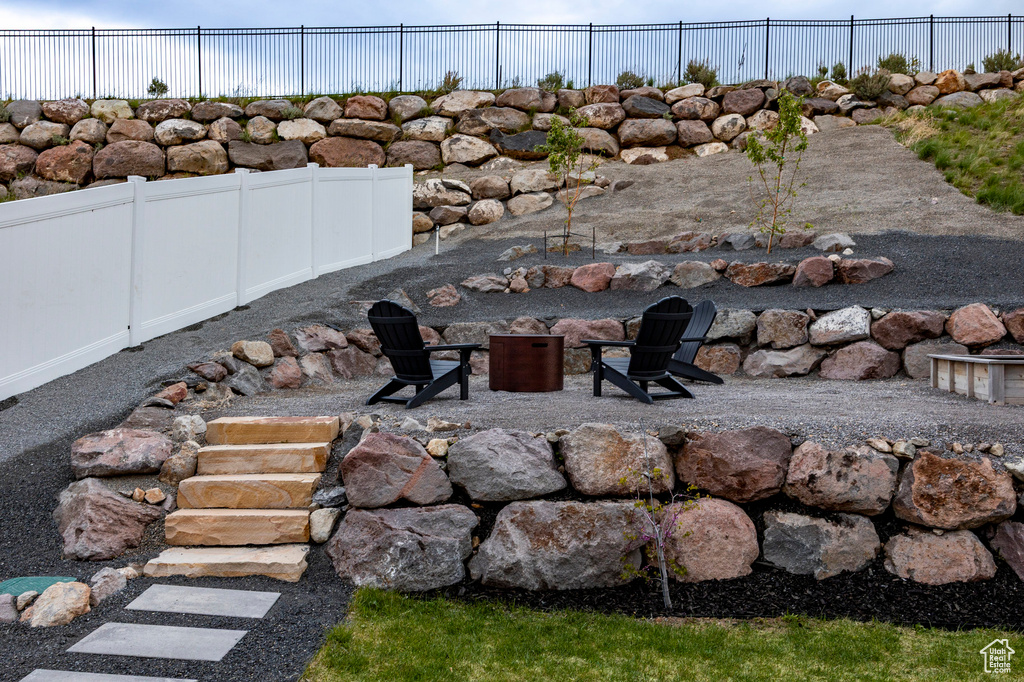 View of yard featuring an outdoor fire pit, fence, and a patio area