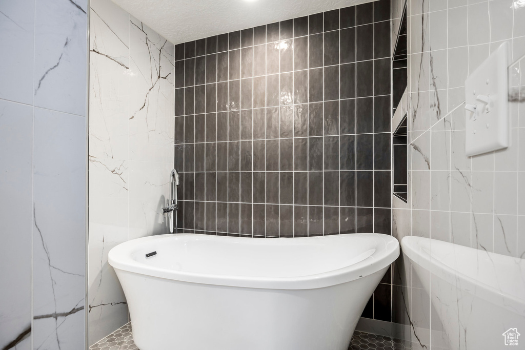 Bathroom with tile walls and a soaking tub