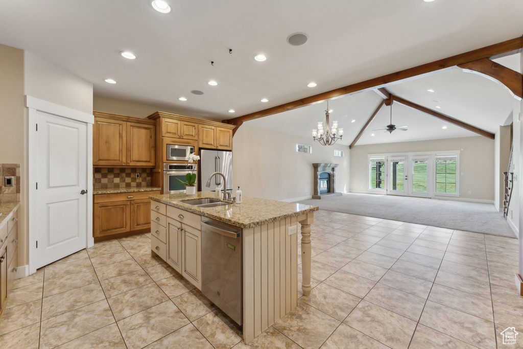 Kitchen with stainless steel appliances, a sink, recessed lighting, light carpet, and open floor plan