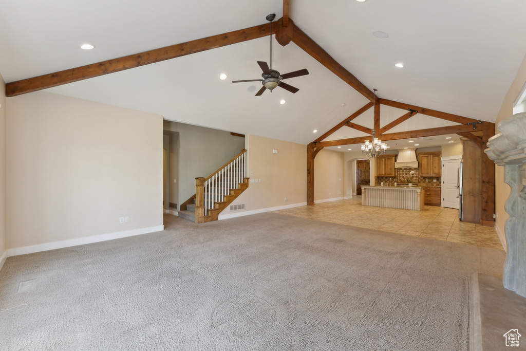 Unfurnished living room with beam ceiling, a ceiling fan, a chandelier, stairs, and baseboards