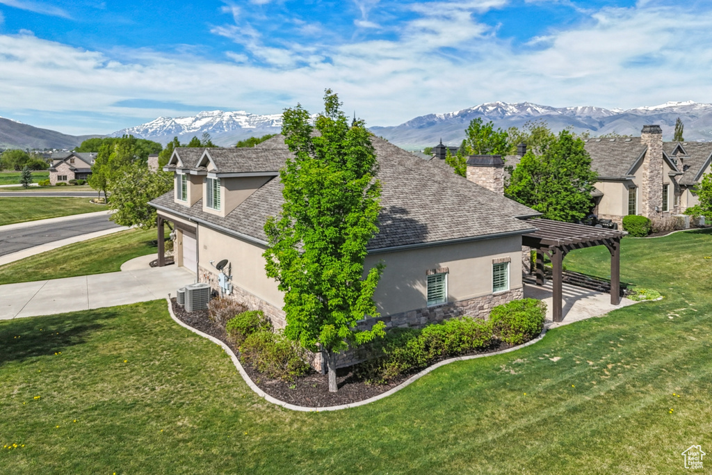 View of side of property featuring stucco siding, stone siding, cooling unit, and a pergola