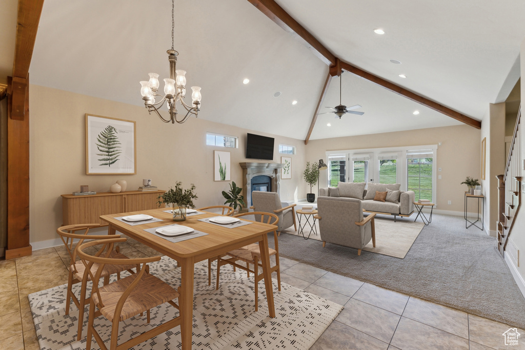 Dining room featuring beam ceiling, a glass covered fireplace, baseboards, light tile patterned floors, and light carpet