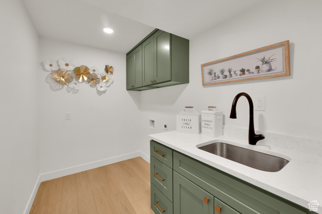 Clothes washing area with cabinet space, hookup for an electric dryer, baseboards, light wood-style floors, and recessed lighting