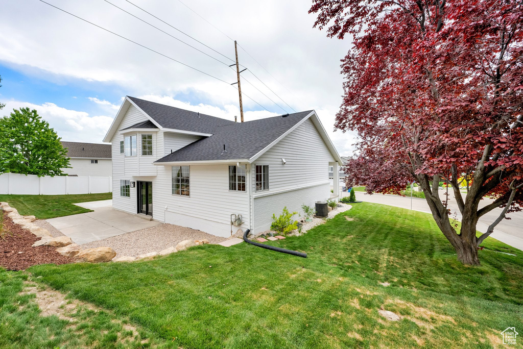 Rear view of house featuring a patio area, roof with shingles, and central air condition unit
