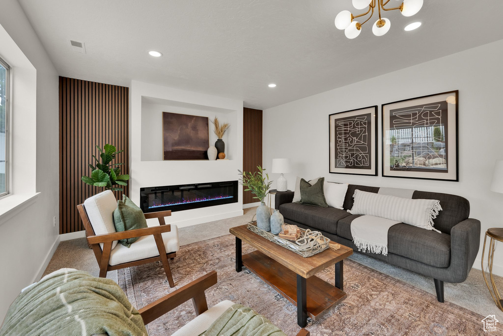 Living room with carpet floors, a chandelier, recessed lighting, baseboards, and a glass covered fireplace