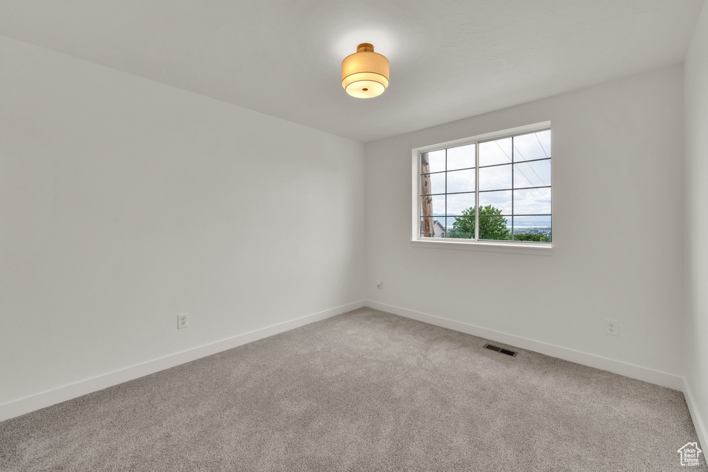 Spare room featuring carpet floors and baseboards