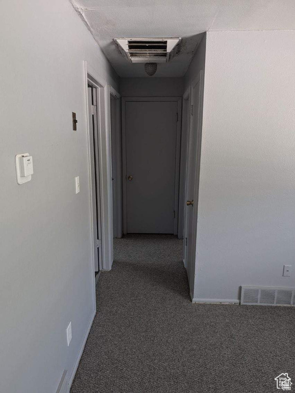 Hall with carpet flooring and baseboards