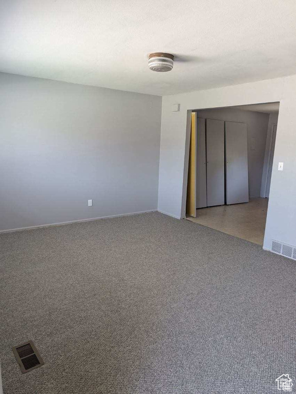 Carpeted spare room featuring baseboards