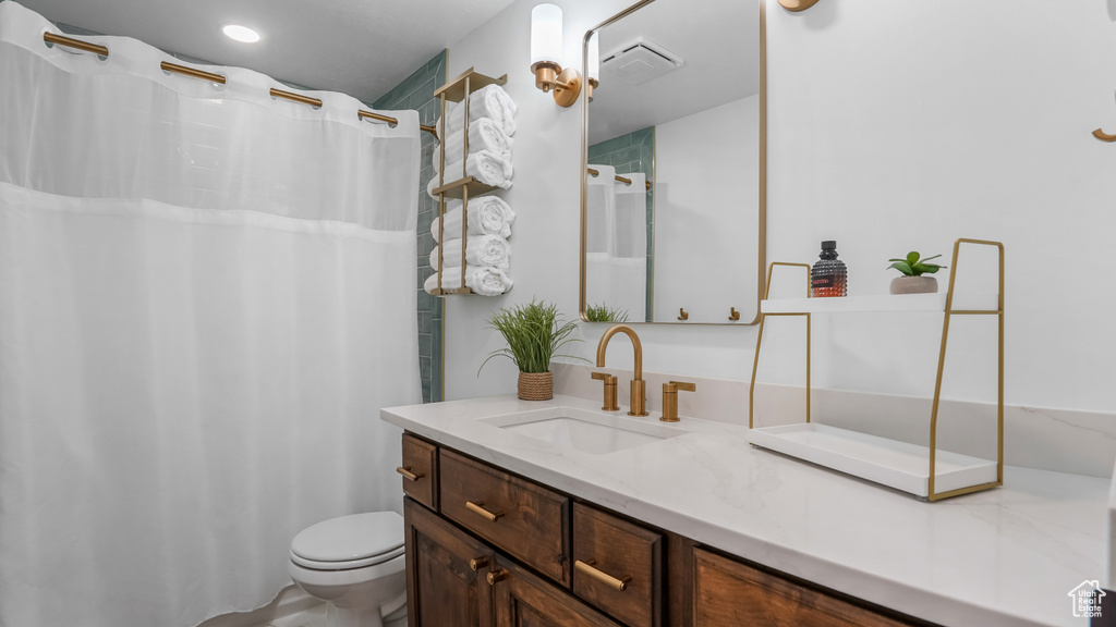 Bathroom with vanity, toilet, and a shower with curtain