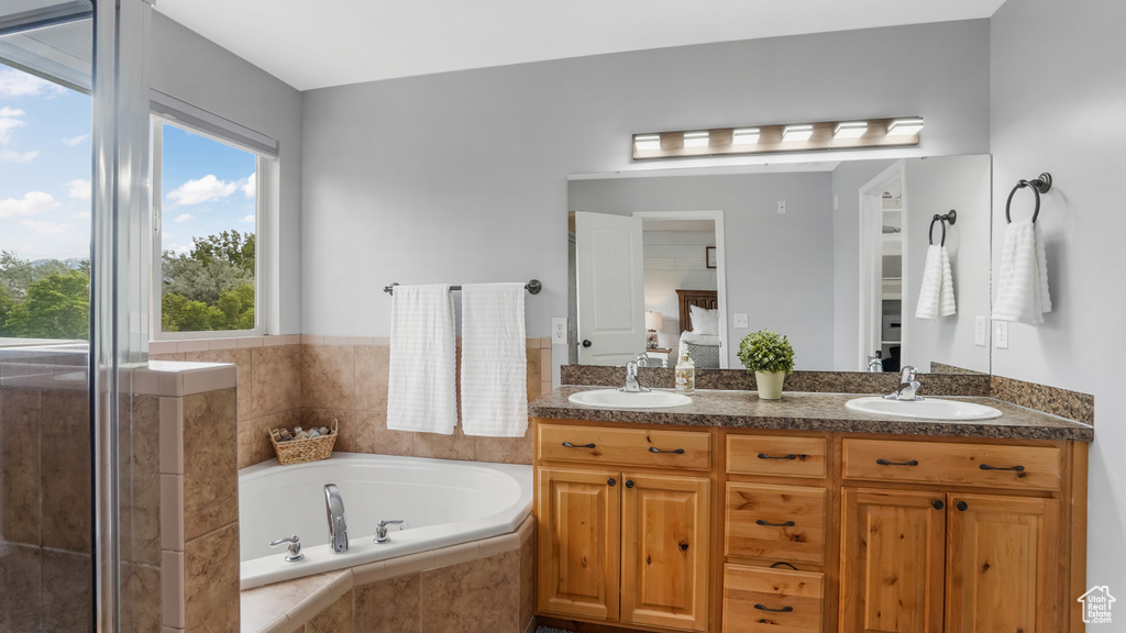 Ensuite bathroom featuring a garden tub and double vanity