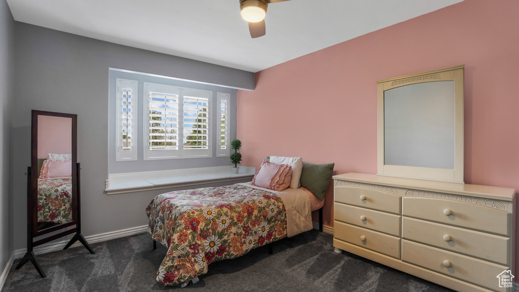 Bedroom with dark carpet, a ceiling fan, and baseboards