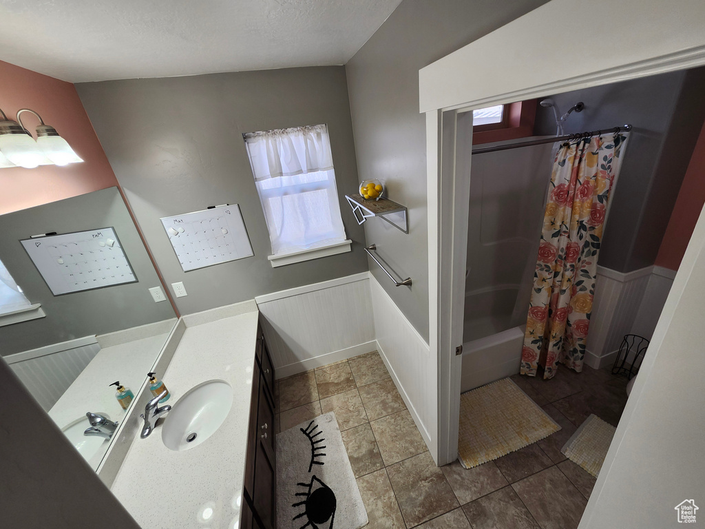 Bathroom featuring wainscoting, vanity, and shower / bath combo