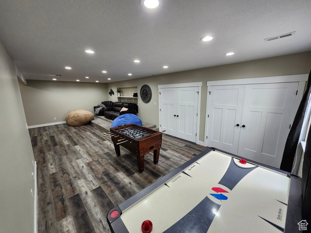 Rec room with baseboards, recessed lighting, wood finished floors, and a textured ceiling