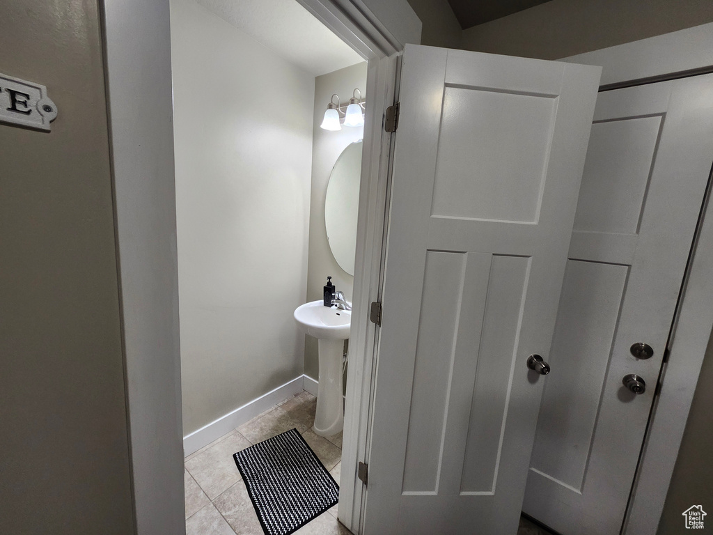 Bathroom with tile patterned floors and baseboards