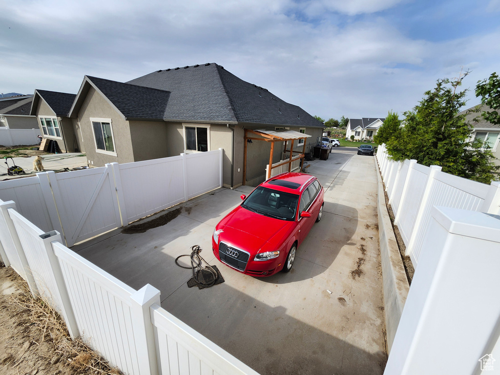 View of home\'s exterior featuring a shingled roof, stucco siding, a residential view, and a fenced backyard