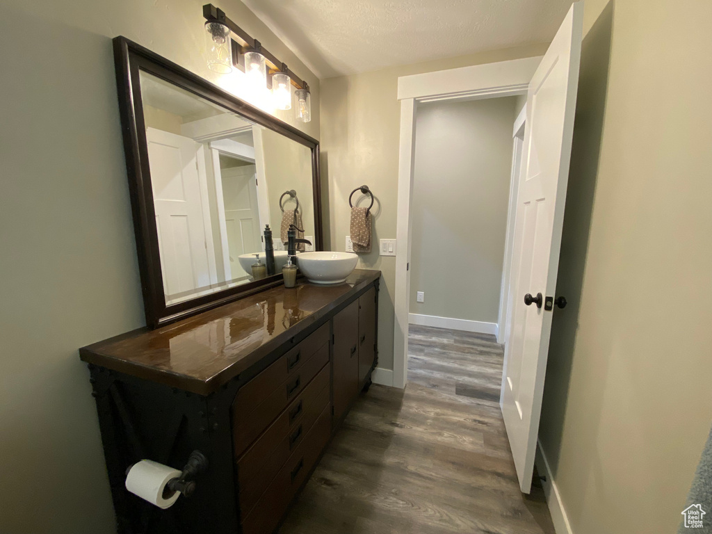 Bathroom with wood finished floors, vanity, and baseboards