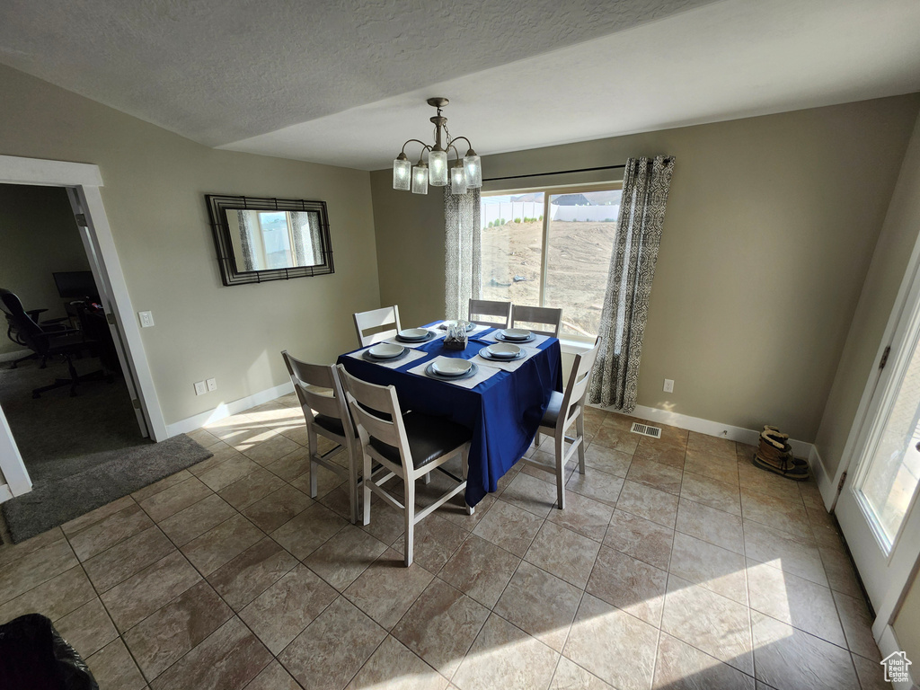 Dining space with a chandelier, baseboards, an office area, and a textured ceiling