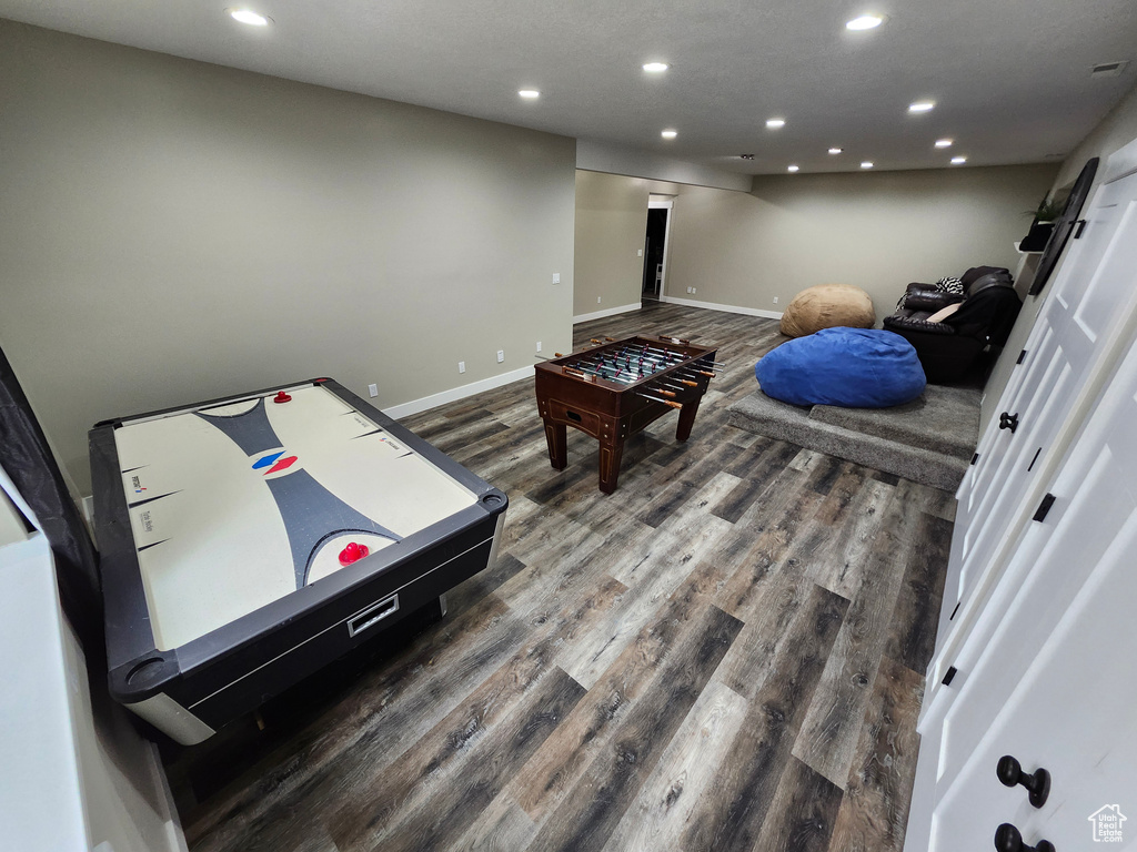 Recreation room with recessed lighting, wood finished floors, and baseboards