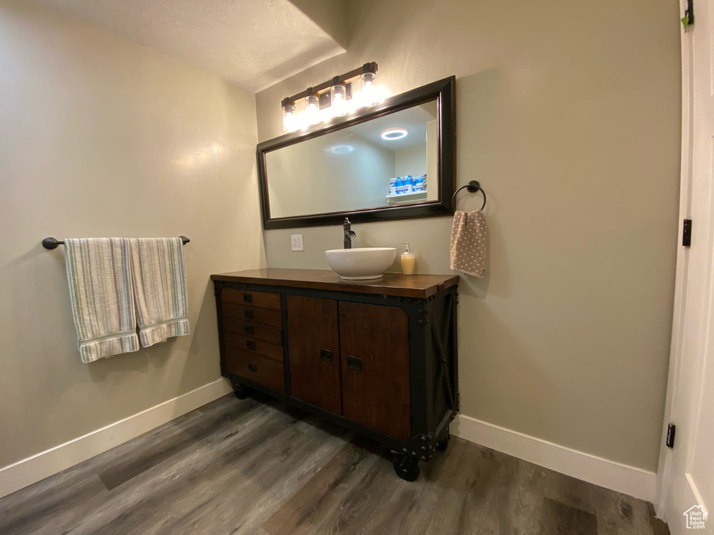 Bathroom featuring wood finished floors, baseboards, and vanity