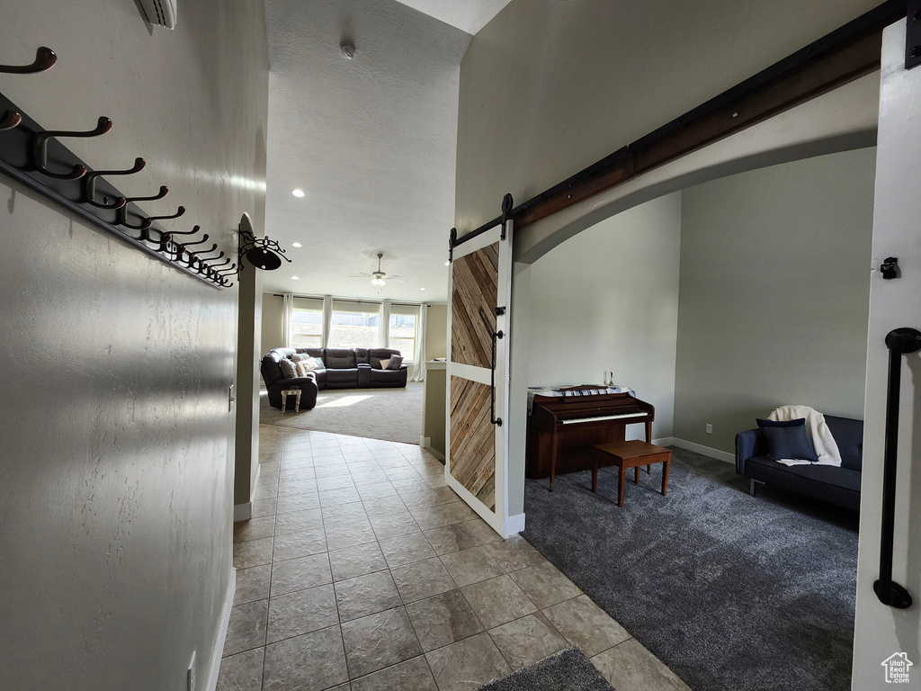 Corridor with a barn door, baseboards, carpet flooring, and recessed lighting