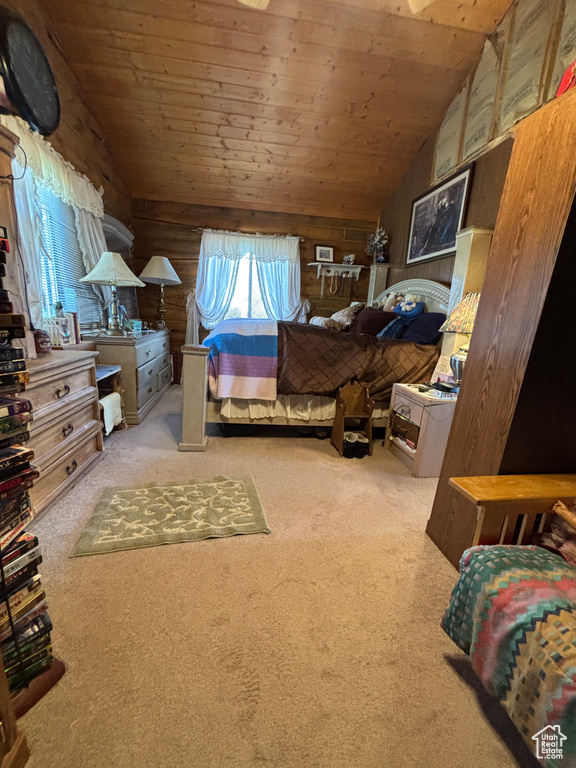 Bedroom with vaulted ceiling, carpet flooring, wooden ceiling, and wood walls
