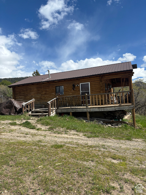 Rear view of property with a deck and metal roof