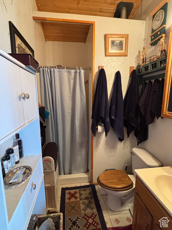 Bathroom featuring toilet, vanity, curtained shower, and wooden ceiling