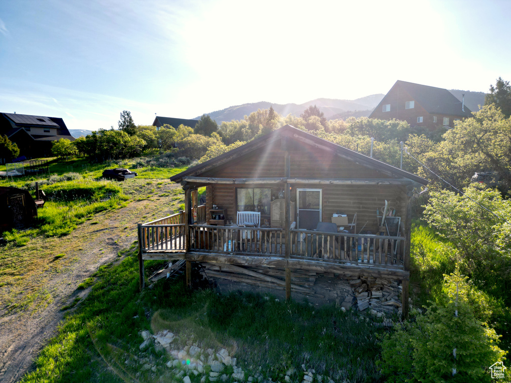 View of front of property with a deck with mountain view