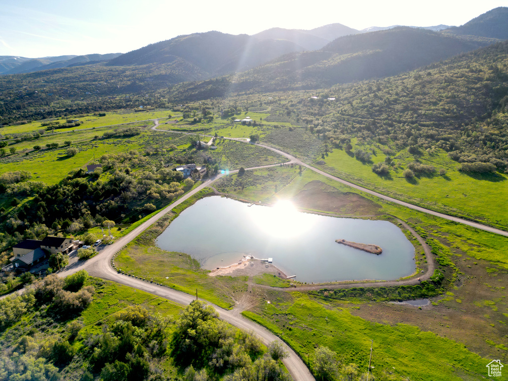 Aerial view of property and surrounding area with a water and mountain view