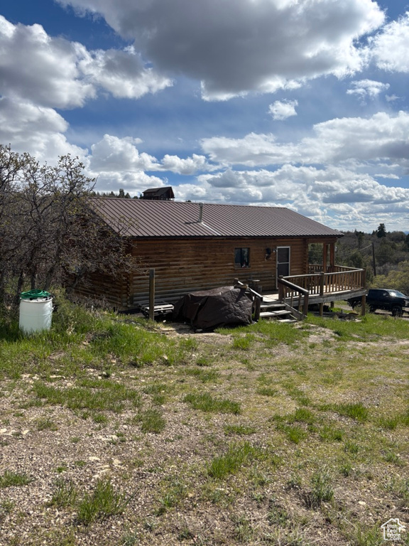 Rear view of house featuring a deck and metal roof