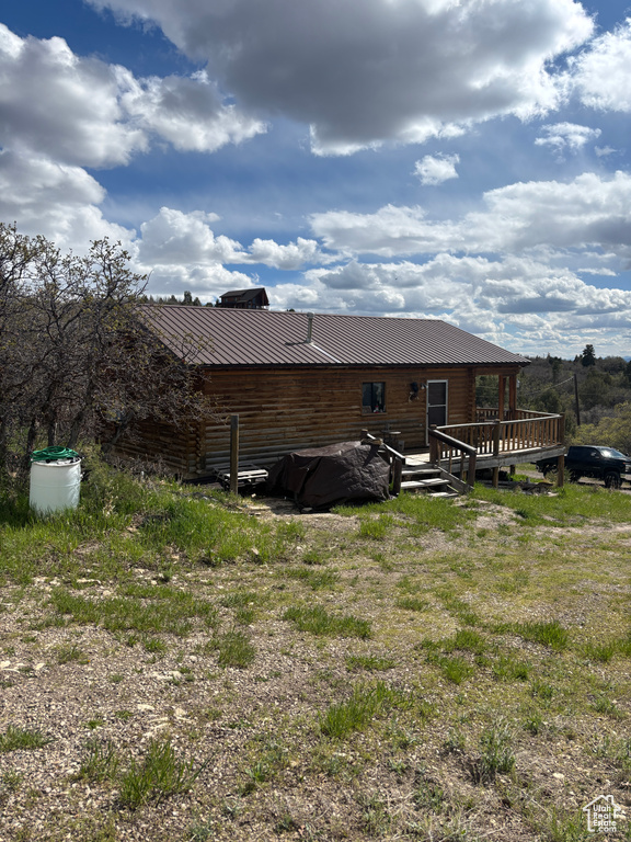 Back of property featuring a deck and metal roof