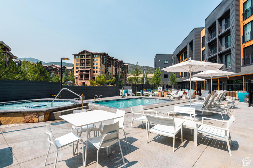 Community pool featuring a hot tub and a patio area