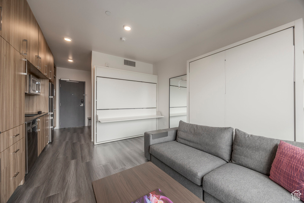 Living area with dark wood-style floors and recessed lighting