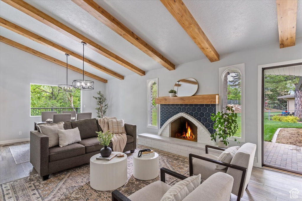 Living room featuring plenty of natural light, a chandelier, and a brick fireplace