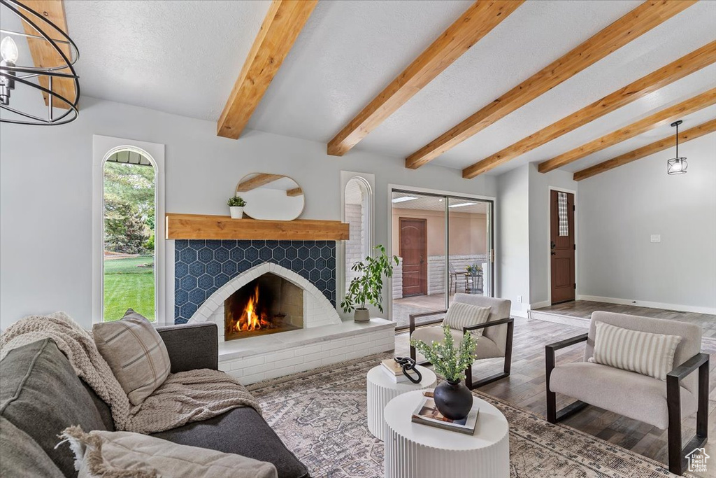 Living room with wood finished floors, a warm lit fireplace, and baseboards