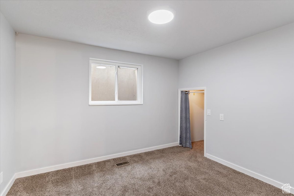 Unfurnished room featuring carpet and baseboards