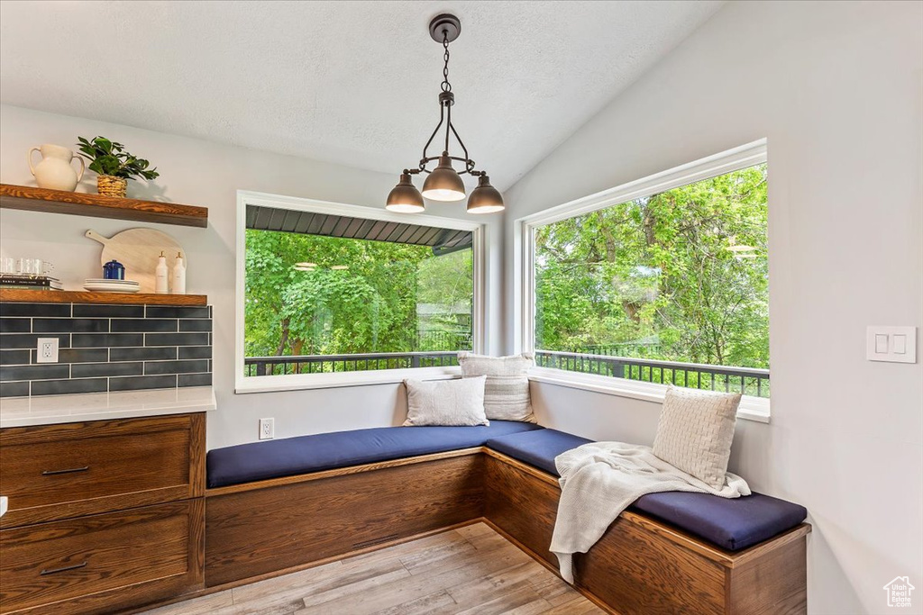 Sitting room featuring lofted ceiling, wood finished floors, and a textured ceiling