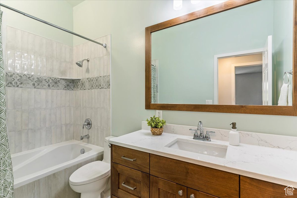 Full bathroom with shower / tub combo with curtain, vanity, and toilet