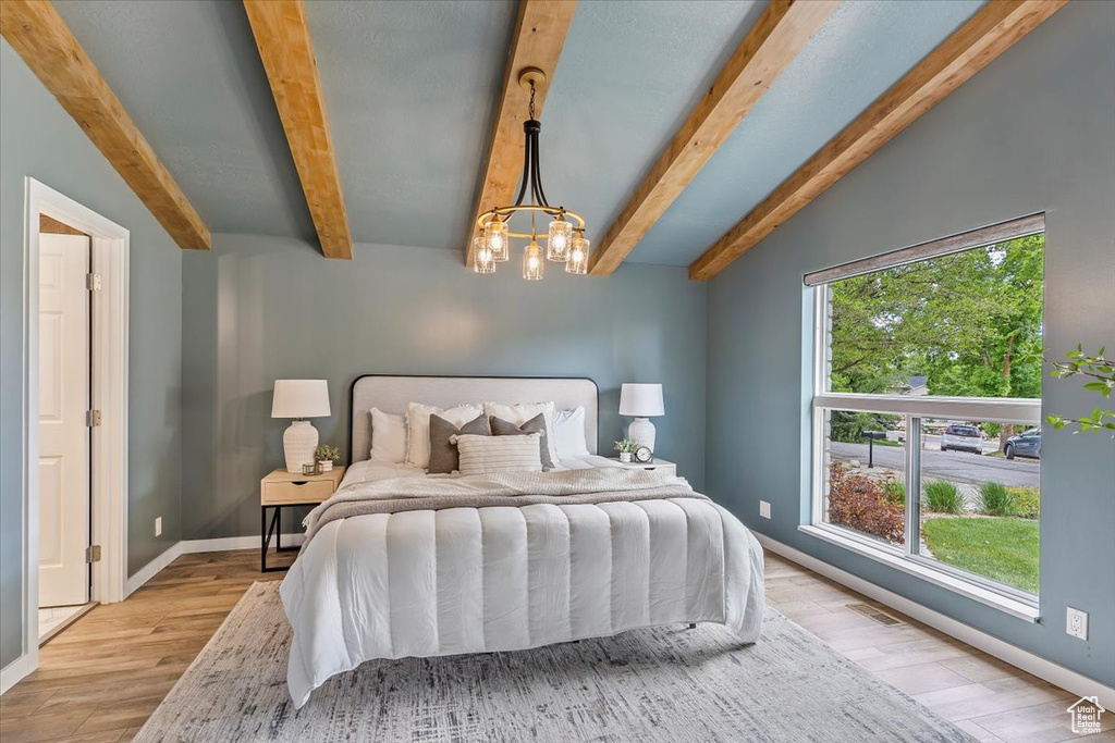 Bedroom with multiple windows, light wood-type flooring, and baseboards