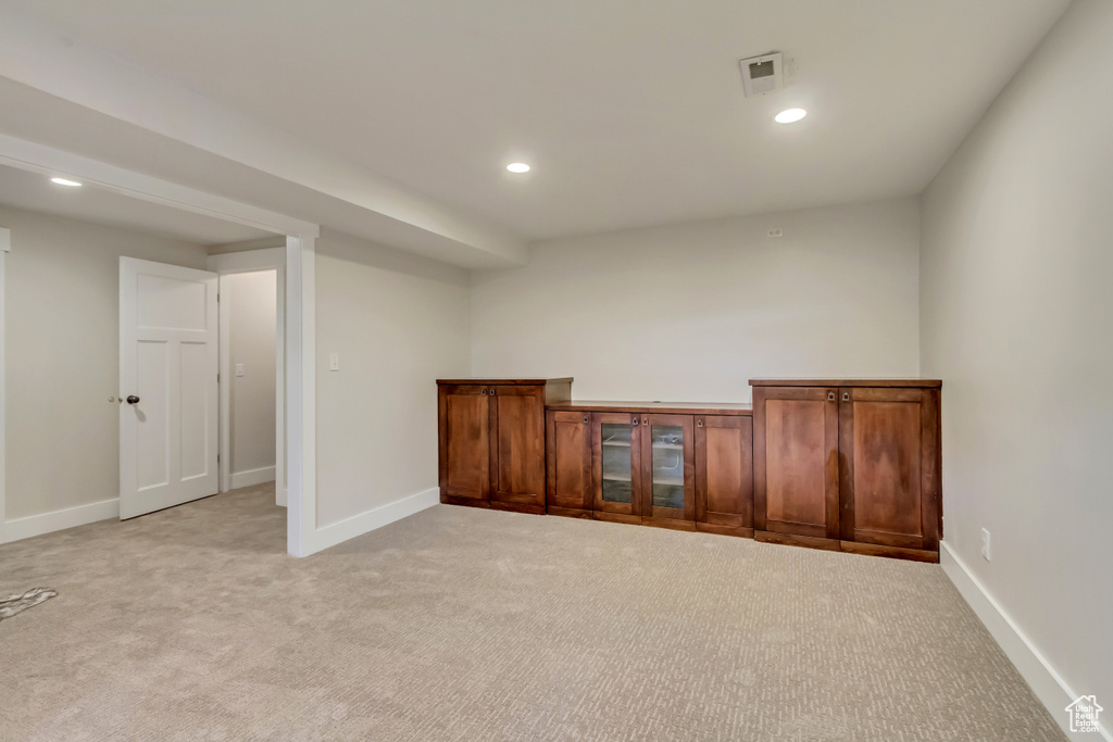 Below grade area with light colored carpet, baseboards, and recessed lighting