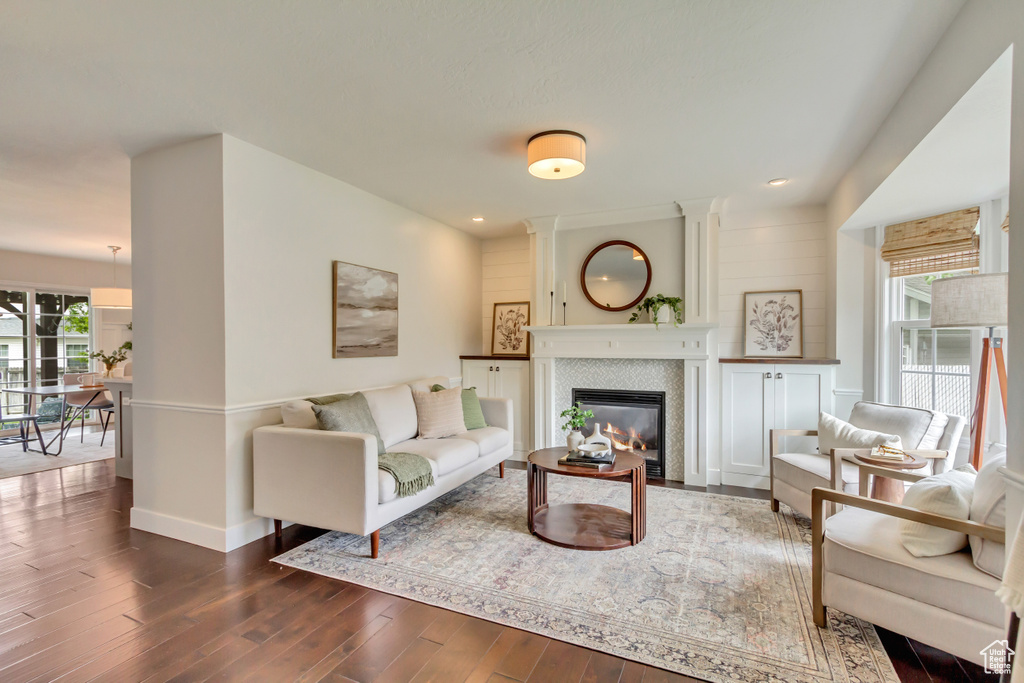 Living area with dark wood-style flooring, a fireplace, baseboards, and recessed lighting
