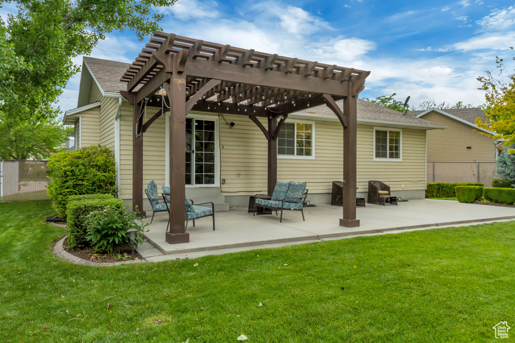 Rear view of house featuring a pergola, a patio area, and roof with shingles
