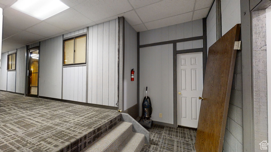 Unfurnished bedroom with carpet, a paneled ceiling, and baseboards